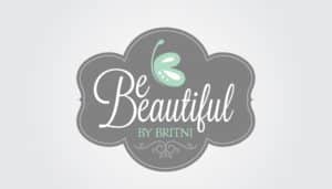 Against a gray and white floral-shaped backdrop reminiscent of ashes, the logo features the text "Be Beautiful by Britni" in elegant white script, rising like a phoenix with flair for small business marketing. Above the text, a mint green butterfly flutters gracefully, bestowing an enchanting touch akin to rebirth and transformation.