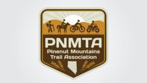 Rising like a phoenix from the heart of the Pinenut Mountains, the Trail Association's logo is expertly crafted with digital marketing flair. It features striking silhouettes of a hiker, horseback rider, motorcyclist, and ATV rider set against a mountainous backdrop ignited by the sun's glow, with an outline of Nevada etched below as if born from flames.